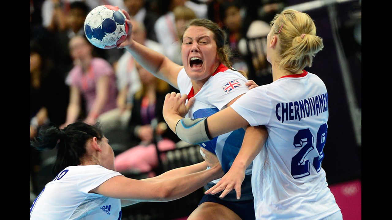 Britain's leftback Ewa Palies, center, fights for possession during the women's preliminaries Group A handball match against Russia on Monday.