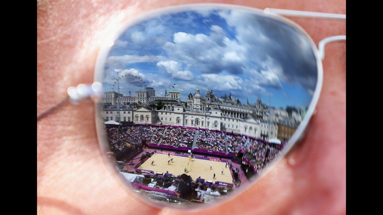 The beach volleyball center court is reflected in the sunglasses of a spectator on Monday.