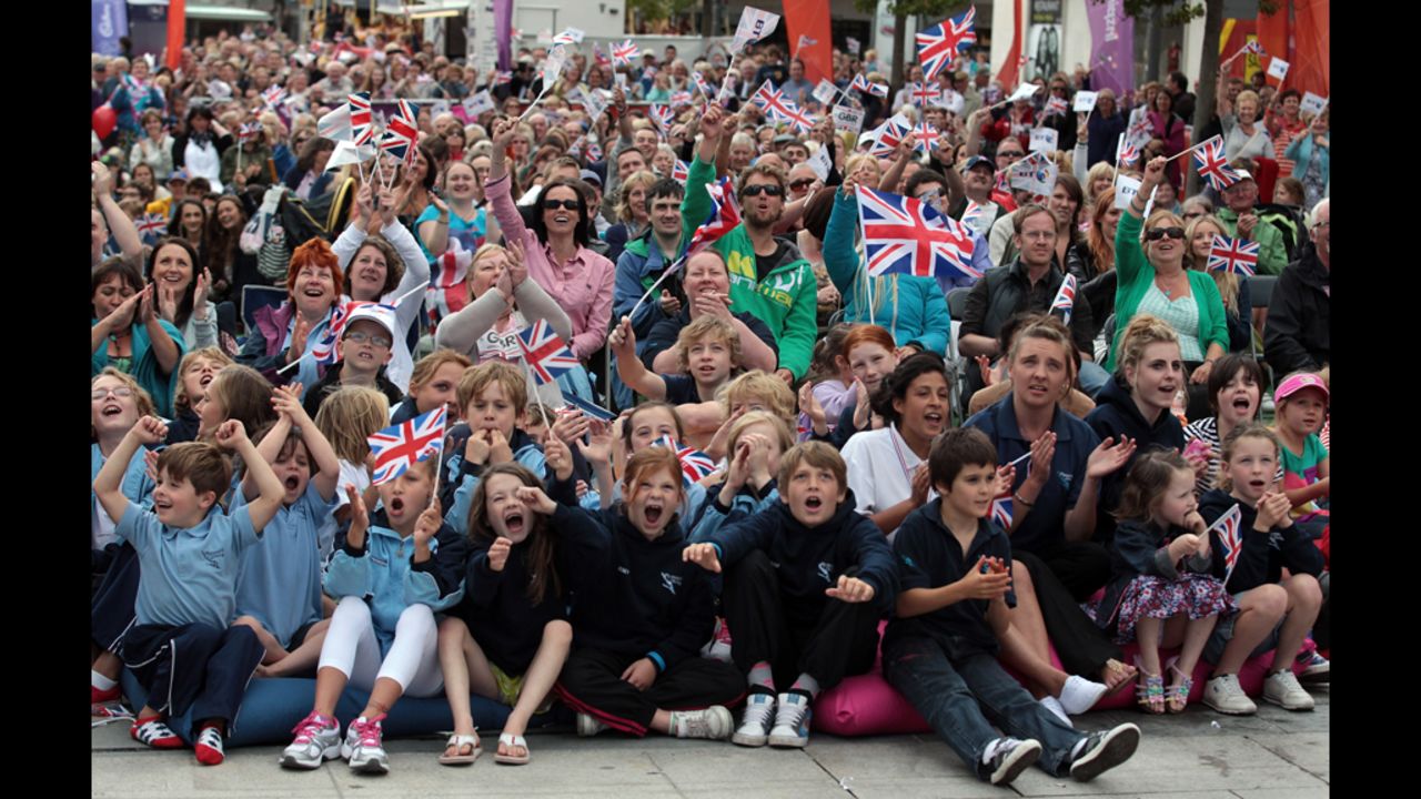 Great Britain supporters cheer as they watch diver Tom Daley on large screens erected in the city center of Plymouth, England on Monday.