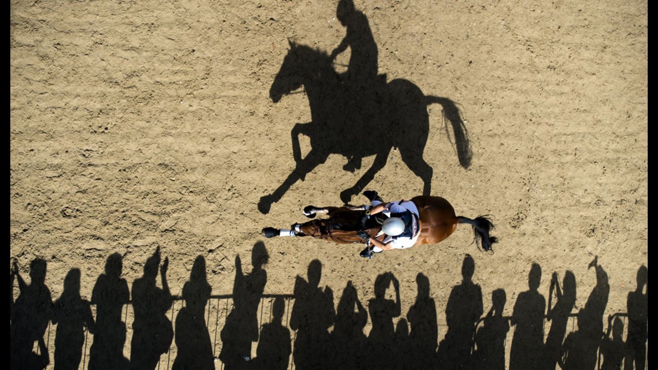 Atop Twizzel, William Coleman of the U.S. rides past spectators as he competes in the cross country equestrian event on Monday.