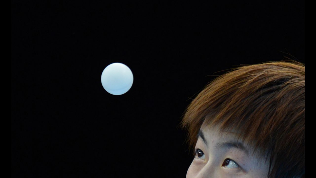Ding Ning of China serves to Jiang Huajun of Hong Kong during a table tennis women's single round match on Monday.