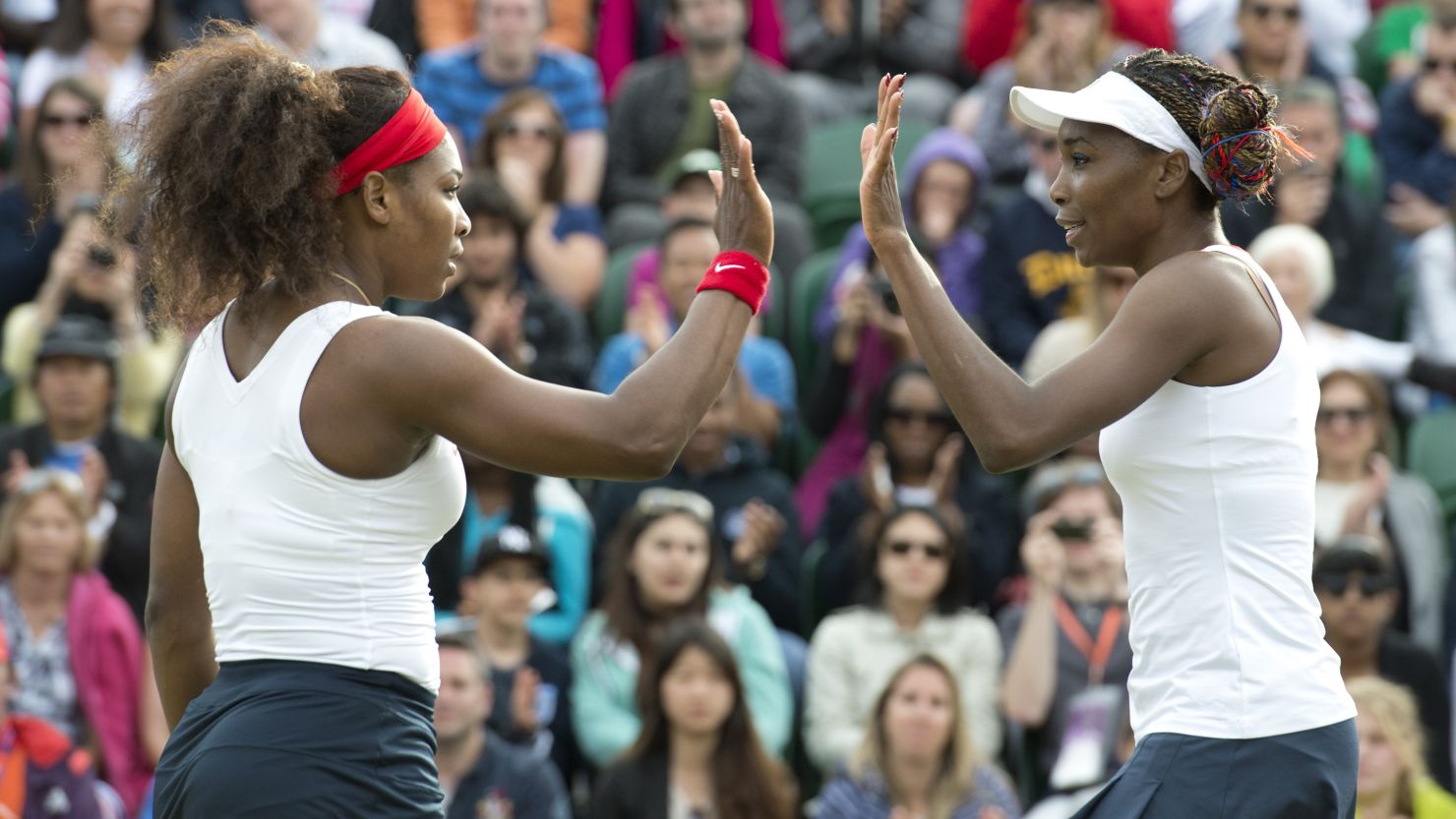 Venus Williams (left) and sister Serena celebrate after beating Romania's Sorana Cirstea and Simona Halep in the doubles.