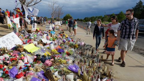 People continue to visit the roadside memorial set up for victims of the theater shooting massacre in Aurora, Colorado. 