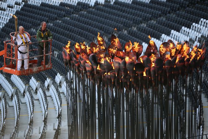 Austin Playfoot lights the cauldron after it was moved into position, ready for the events in Olympic Stadium, on Monday, July 30, in London.