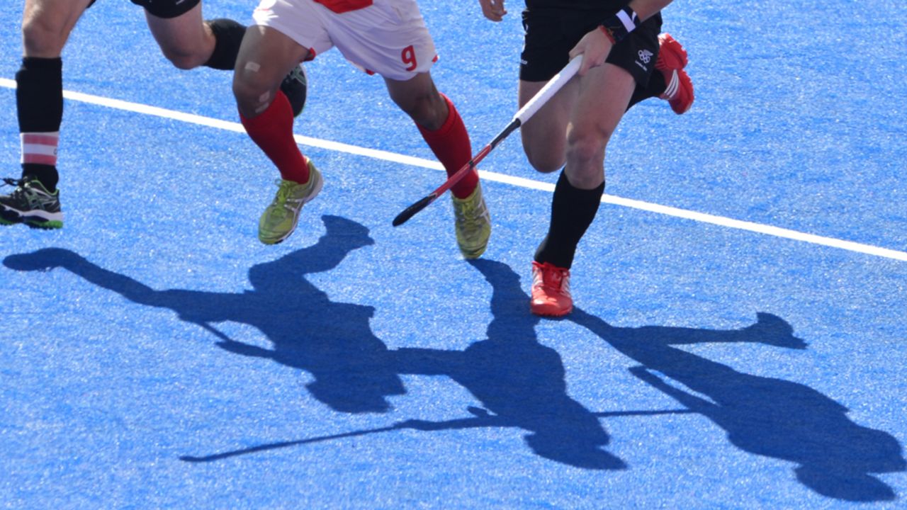 South Korea's Yung Sung Hoon dribbles past New Zealand defenders during the preliminary round men's field hockey match Monday.