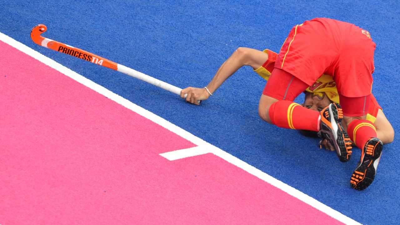 Spain's Jose Ballbe struggles to plant himself during a field hockey match.