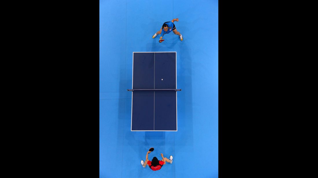 Japan's Kasumi Ishikawa, in red, faces off against Wang Yuegu of Singapore during a women's singles table-tennis match Tuesday.