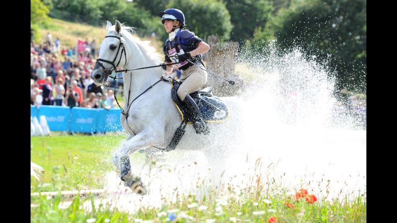 Vittoria Panizzon of Italy, riding Borough Pennyz, makes a splash in the water in the eventing cross country equestrian event.