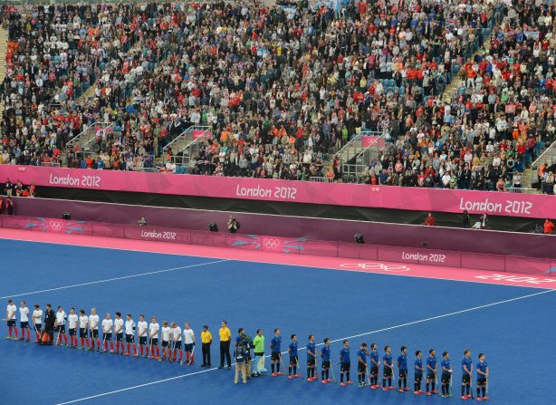 British and Argentinian team players line up at the start of the preliminary round men's field hockey match.