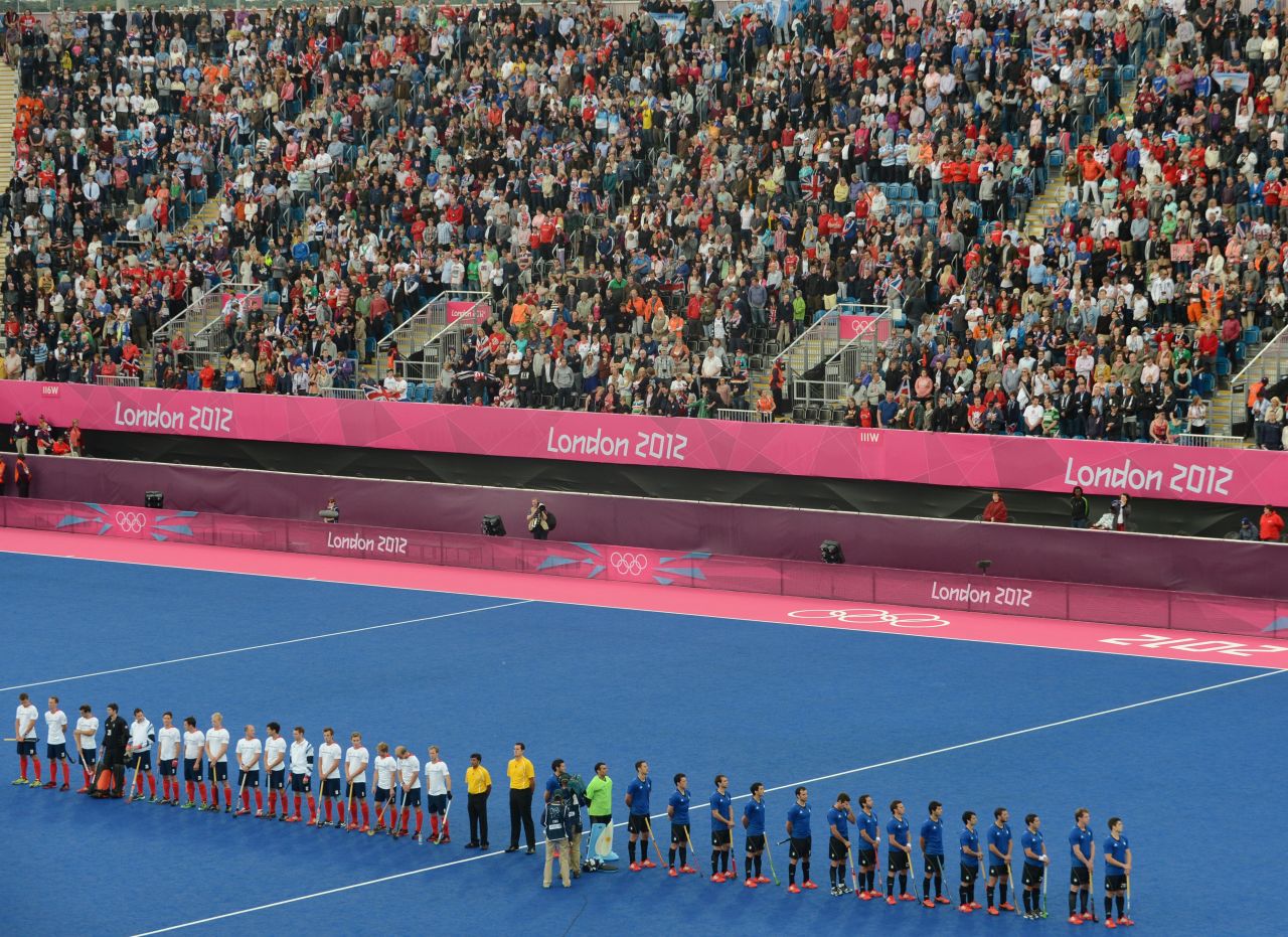 British and Argentinian team players line up at the start of the preliminary round men's field hockey match.