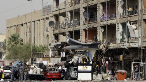 Iraqi security gather at the site of twin car bombs in the Karrada area of the capital Baghdad on July 31, 2012.