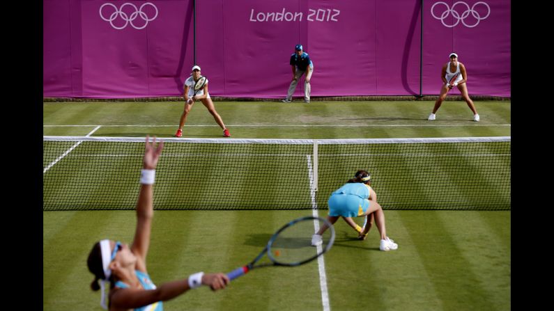 Yaroslava Shvedova of Kazakhstan serves next to her partner Galina Voskoboeva of Kazakhstan during the women's doubles tennis match against Maria Kirilenko and Nadia Petrova of Russia.