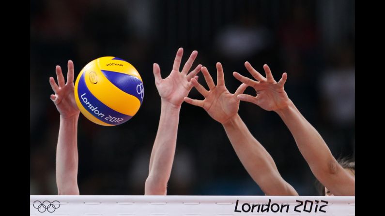 A detailed view of hands and the ball in the women's volleyball preliminary match between Great Britain and Algeria.