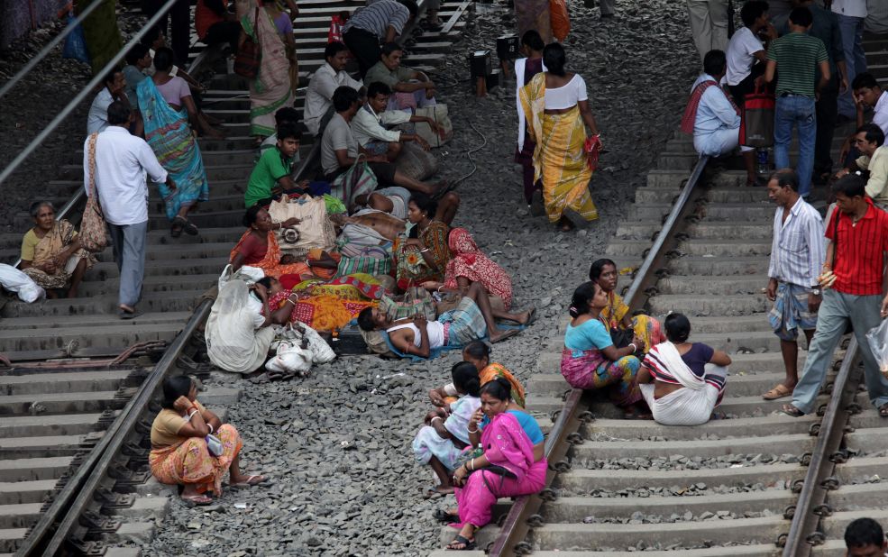 Passengers wait on the tracks for a train during a massive electricity failure at a station in Kolkata, formerly known as Calcutta, on Tuesday. India suffered its second huge, crippling power failure in two days Tuesday, depriving up to 600 million people of electricity and disrupting transport networks.