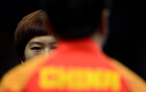 Li Xiaoxia of China talks with her coach during a table tennis women's quarterfinals match Tuesday.