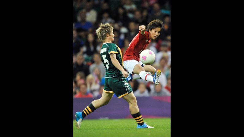 South Africa's Janine Van Wyk, left, and Mana Iwabuchi of Japan go after the ball during the women's football first round match Tuesday at Millennium Stadium in Cardiff, Wales.