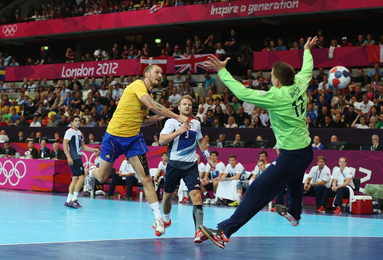 Sweden's Fredrik Petersen scores on Robert White of Great Britain during the men's handball preliminary match between Britain and Sweden on Tuesday.