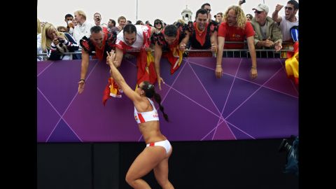 Spain's Liliana Fernandez celebrates with fans after her team's beach volleyball preliminary match against Argentina. Spain won 2-0.