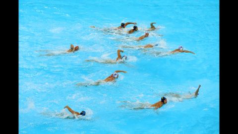 Australian and Kazakh athletes swim for the ball during a men's water polo preliminary round at Water Polo Arena in London.
