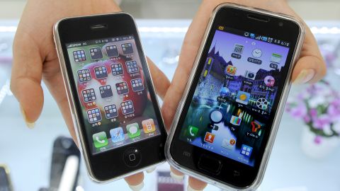 A South Korea shop manager shows Samsung Electronics' Galaxy S mobile phone, right, and Apple's iPhone 3G.