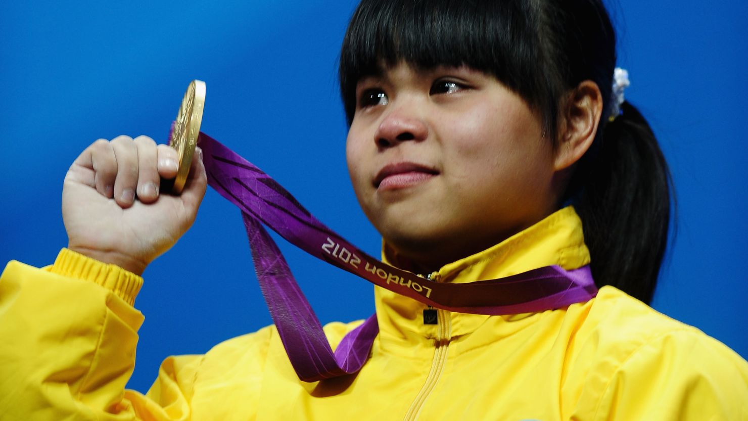 Zulfiya Chinshanlo of Kazakhstan stands with her gold medal on the podium after the Women's 53kg Weightlifting event.