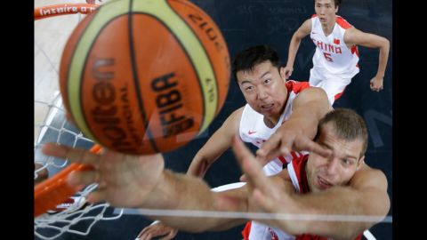 China's Wang Zhizhi, left, tries to block Sergey Monya of Russia from scoring during the men's preliminary round basketball match on Tuesday.