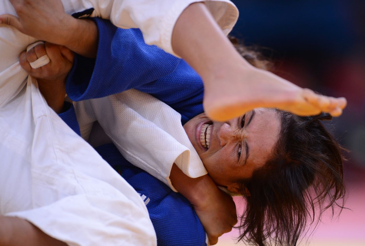 Turkmenistan's Gulnar Hayytbaeva, in blue, fights with Azerbaijan's Ramila Yusubova during the women's under 63-kilogram judo match Tuesday.