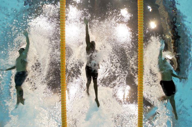 From left, Ahmed Husam of the Maldives, Mamadou Soumare of Mali and Beni Bertrand Binobagira of Burundi compete in the men's 100-meter freestyle heat Tuesday. See photos from <a target="_blank">day five of the competition</a> from Wednesday, August 1.