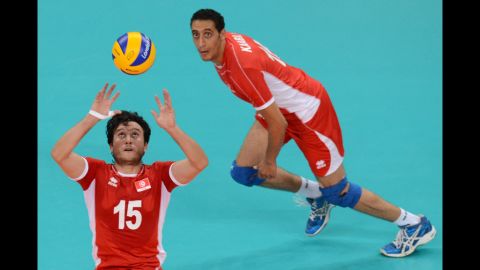 Tunisia's Mehdi Ben Cheikh, left, sets the ball during the men's preliminary volleyball match between Serbia and Tunisia on Tuesday.