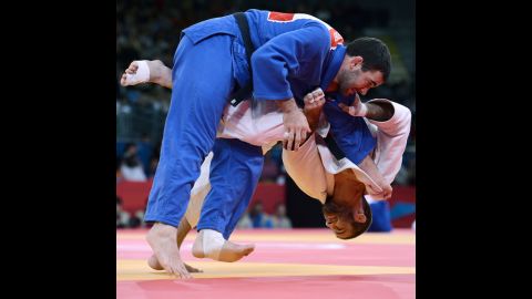 Travis Stevens, in white, of the United States tries to take down Slovenia's Aljaz Sedej during the men's under 81-kilogram judo contest match Tuesday.