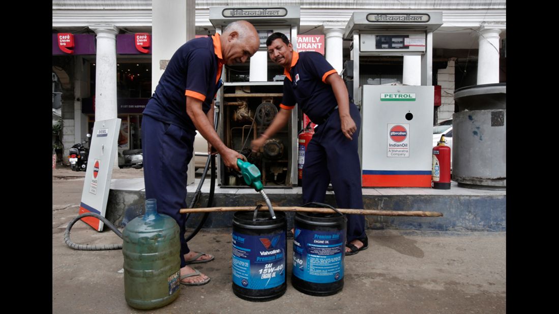 Employees manually fill containers with diesel in New Delhi on Tuesday.