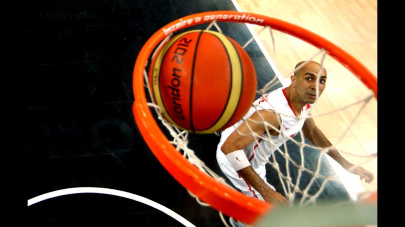 Radhouane Slimane of Tunisia watches as U.S. player Andre Iguodala's layup goes in the net during their preliminary basketball match.