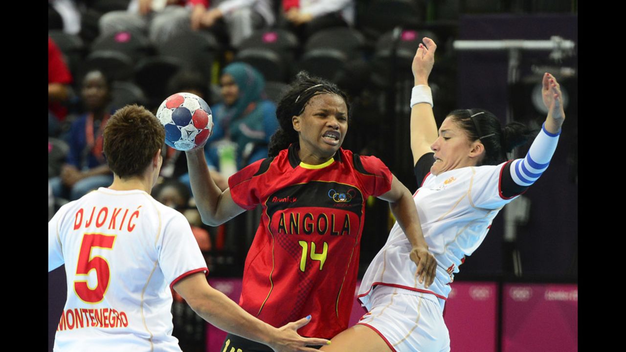 Angola's Natalia Bernardo, center in red, vies with Montenegrin players during a women's preliminary handball match.