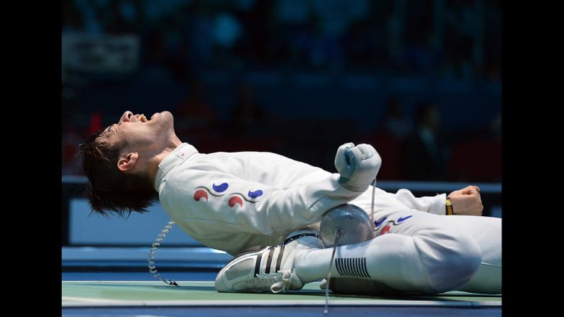 South Korea's Jung Jinsun celebrates his victory over Germany's Jorg Fiedler at the end of their men's epee fencing bout.
