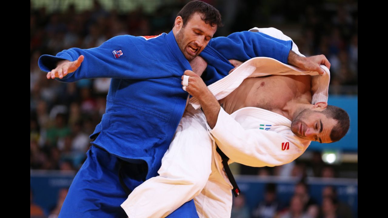 Roberto Meloni of Italy, in white, competes with Parviz Sobirov of Tajikistan during a men's under 90 kilogram Judo event.