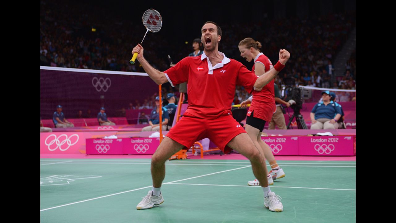 Joachim Fischer and Christinna Pedersen of Denmark celebrate beating Sudket Prapakamol and Saralee Thoungthongkam of Thailand in their mixed doubles badminton match.