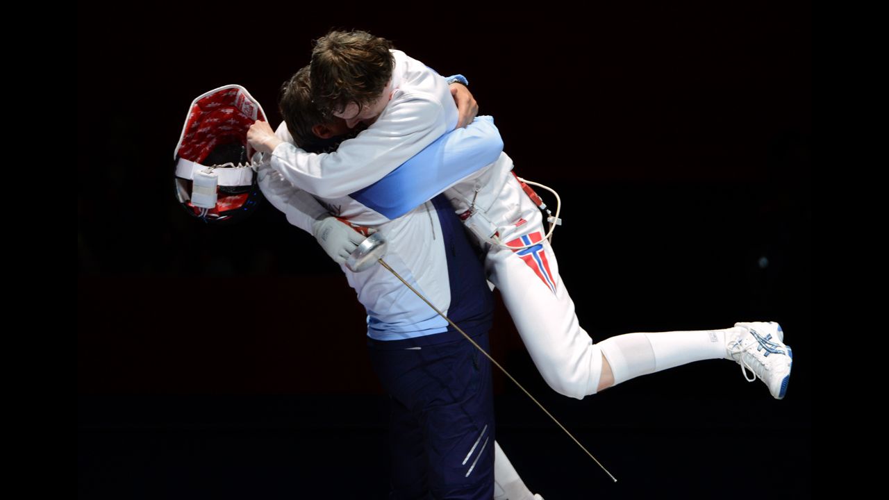 Norway's Bartosz Piasecki celebrates with his coach after beating South Korea's Jung Jinsun in the men's epee semifinal fencing bout.