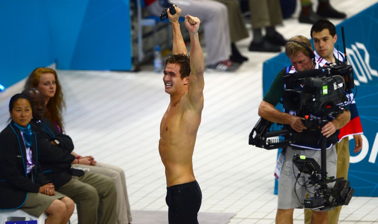 American swimmer Nathan Adrian raises his hands in triumph. 