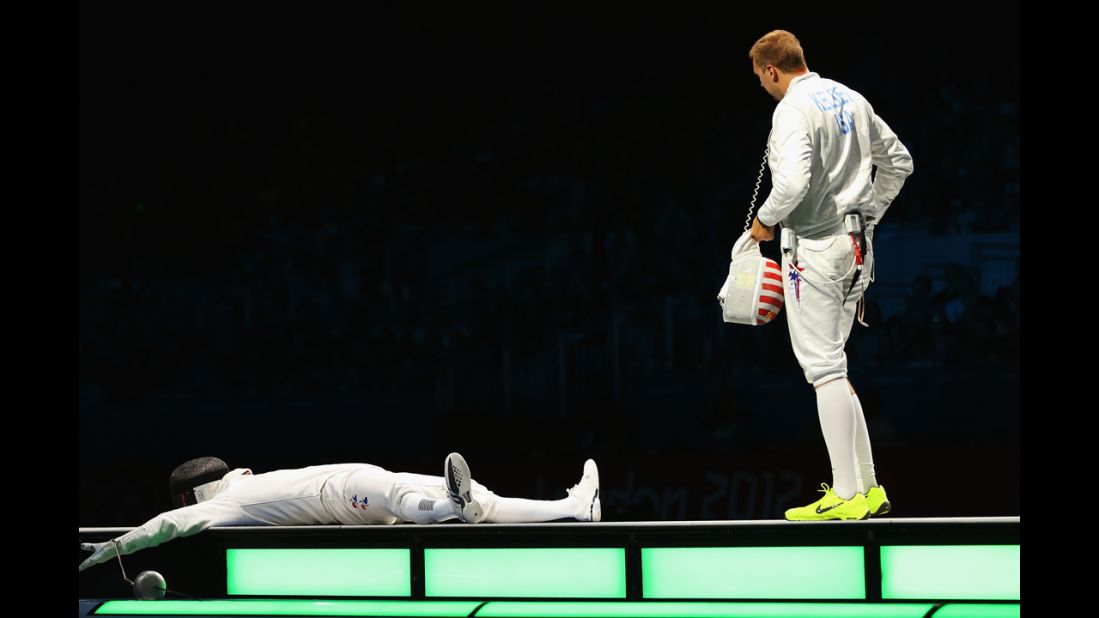 Jinsun Jung collapses after winning the men's epee individual fencing bronze medal match against Seth Kelsey of the United States.