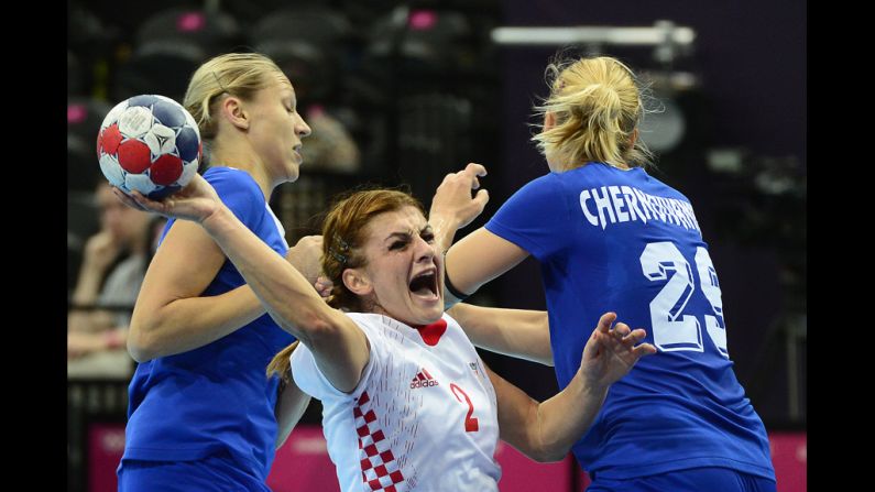 Croatia centerback Miranda Tatari, center, vies with Russian players during the preliminaries in women's handball.