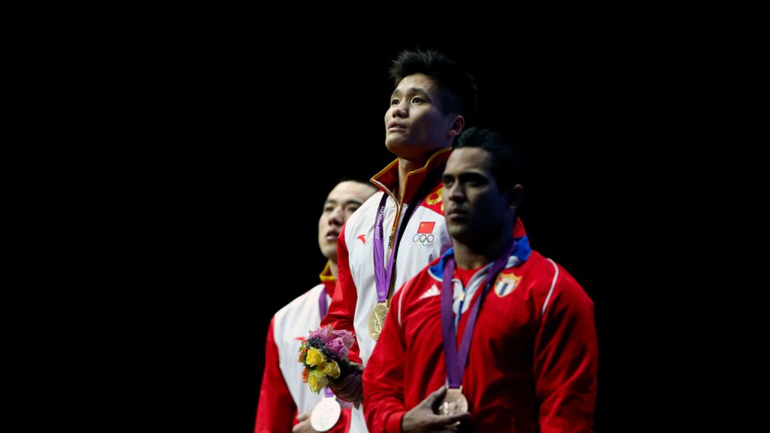 Left to right: Haojie Lu of China (silver), Xiaojun Lu of China (gold) and Ivan Cambar Rodriguez of Cuba (bronze) stand on the podium during the medal ceremony for men's 77-kilogram weightlifting event.
