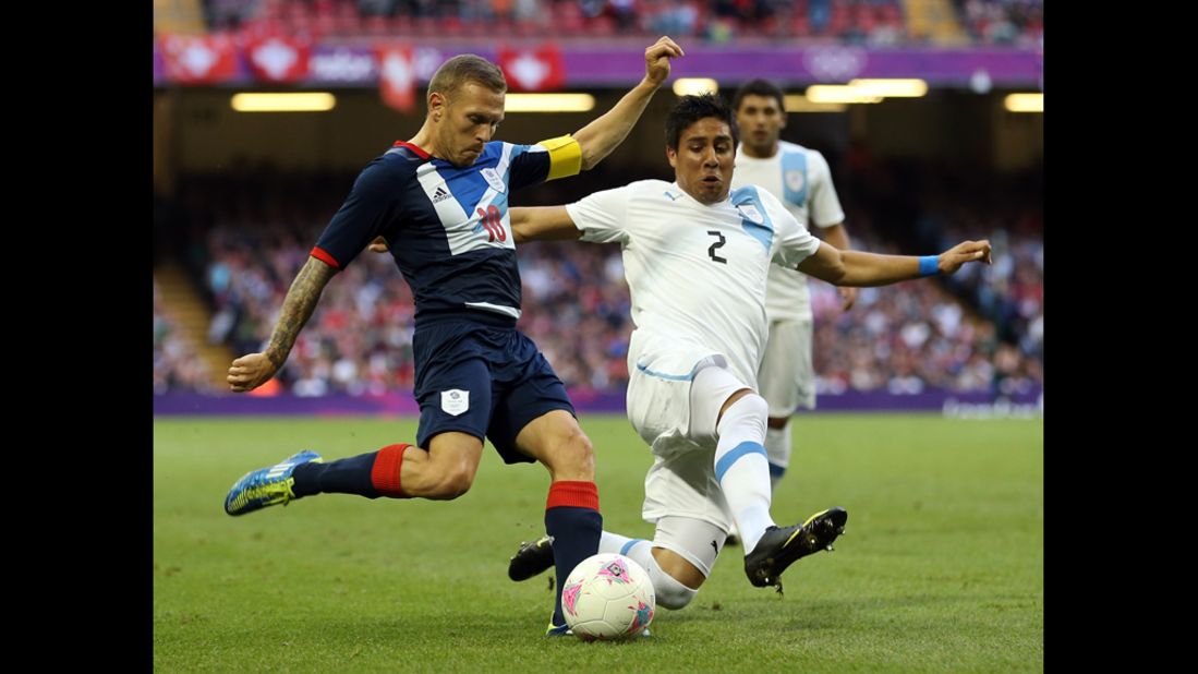 Craig Bellamy of Britain battles with Ramon Arias of Uruguay during the a men's Group A football match in Cardiff, Wales.
