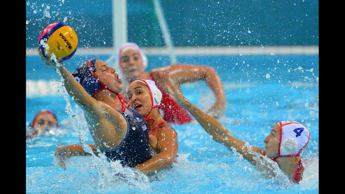 Left to right: Brenda Villa of the United States is challenged by Spain's Anni Espar Llaquet and Roser Tarrago Aymerich in a women's Group A water polo preliminary.