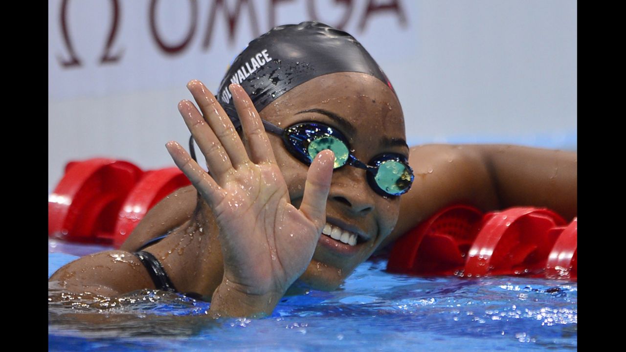 Arianna Vanderpool-Wallace of the Bahamas waves to the crowd after the women's 100-meter freestyle heats Wednesday.