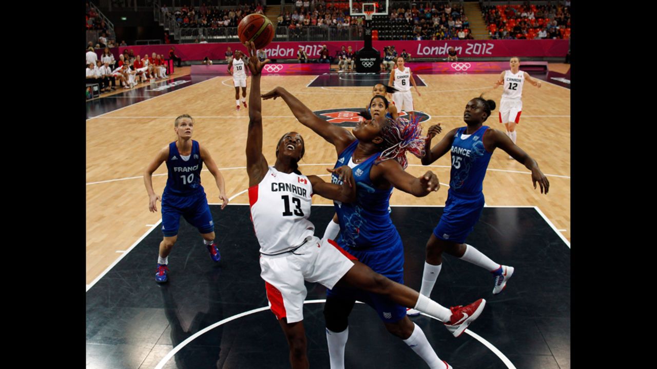 Isabelle Yacoubou of France, center, fights Tamara Tatham of Canada for the ball during a women's preliminary basketball match Wednesday.