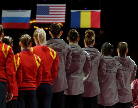 The U.S. team, left, takes the podium after winning the gold medal in the women's gymnastics event. Russia took silver and Romania won the bronze.