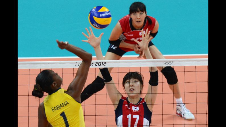 Brazil's Fabiana Claudino, left, spikes as South Korea's Yang Hyo-Jin, right, attempts to block during the women's preliminary group B volleyball match.