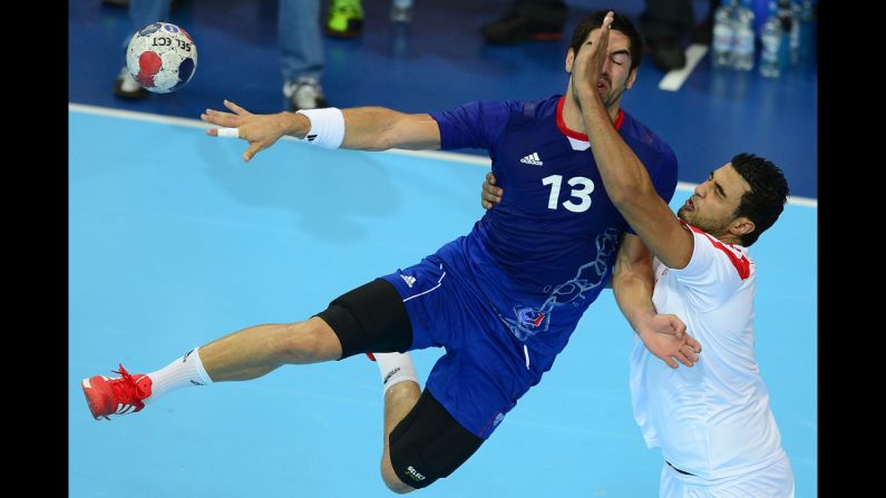 French centerback Nikola Karabatic, left, vies with a Tunisian opponent during a men's preliminary handball match.