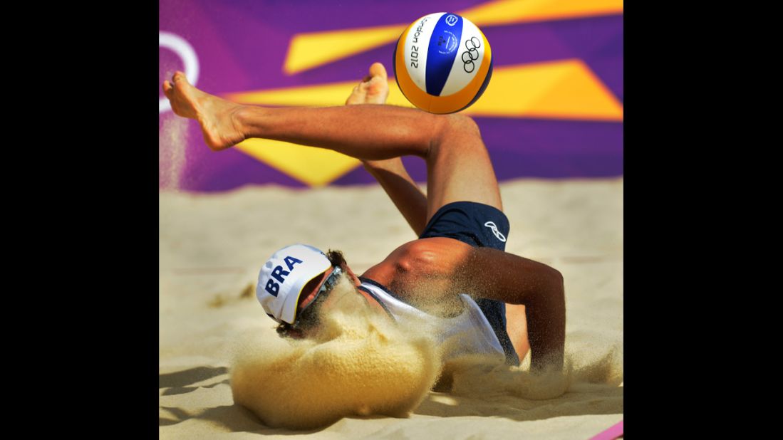 Brazil's Emanuel Rego lands after saving a ball during the men's beach volleyball preliminary phase match against Italy.