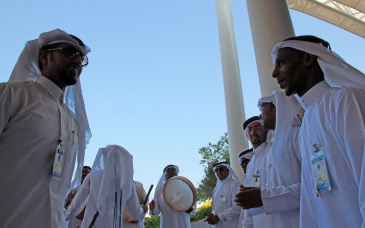 Qatari musicians drum up visitors to the country's pavilion. "It's about people, not business," says its manager Mona Sulaiti. 